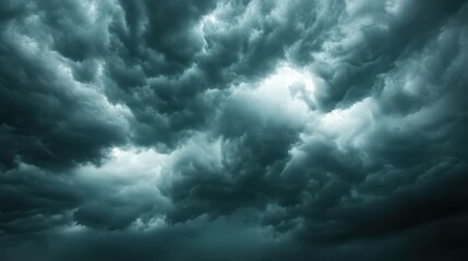 Cloudy sky with dark storm clouds and distant light rays breaking through