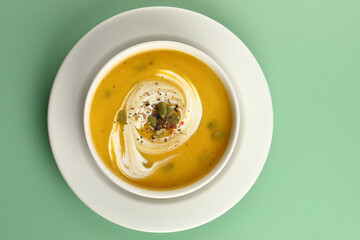 Pumpkin traditional soup with creamy silky texture garnished with pumpkin seeds 