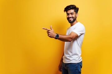 Happy Young Man Pointing with Confidence Against Bright Yellow Background, Perfect for Motivational Posters and Advertisements