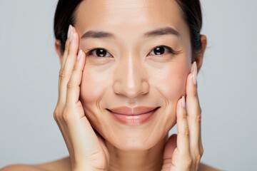 Radiant Asian Woman Smiling with Hands on Face, Perfect for Skincare and Beauty Product Advertising