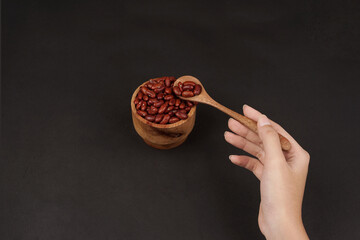 A Hand Holding a Spoonful of Red Kidney Beans
