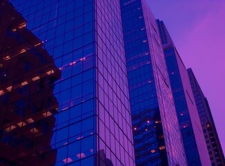 Purple-hued skyscrapers at dusk, reflecting city lights.