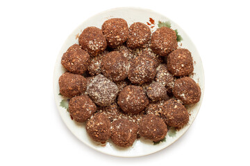 There are many small round homemade cakes. Pile of chocolate balls in a plate on a white background.