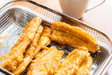 Golden, crispy banana fritters, perfectly fried to achieve a crunchy exterior while maintaining a soft, sweet interior