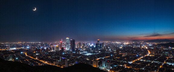 Obraz premium Bustling metropolis under crescent moon at night, Ramadan atmosphere
