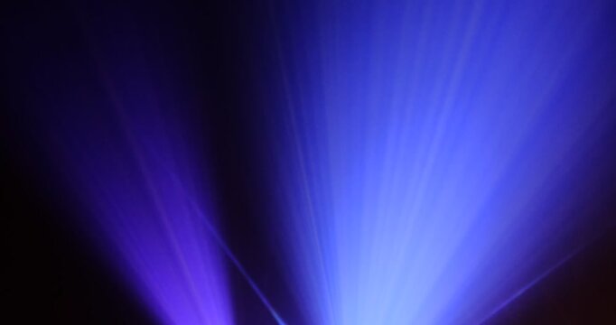 Lasershow with Multiple Laser Beams in Fog, The concepts of performance arts, Colored light beams from reflector through the foggy night sky
