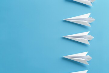 Paper planes breaking formation on blue background.