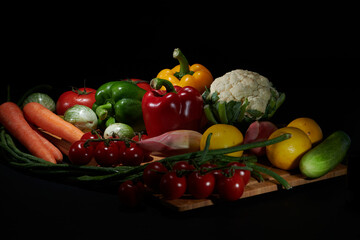 Fresh vegetables for cooking or eating raw photographed against a dark background