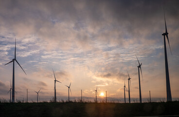 Wind turbines generating electricity in Austria during sunset.