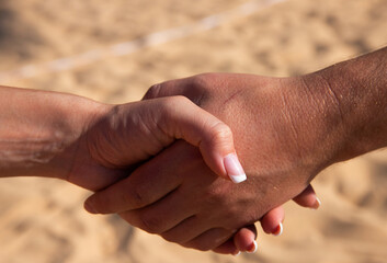 Handshake. Female and male hand on sand background. Copy space