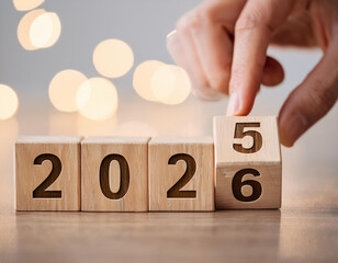 New Year Goals 2026. Flipping numbers 2025 to 2026 on a wooden block cube on a light bokeh