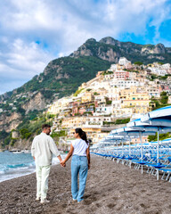 Couple strolls hand in hand along the sandy shores of Positano o