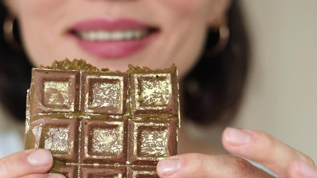 Close up of woman portrait eating handmade Dubai chocolate with green pistachio paste, cream and kataifi dough isolated on white background. Trend dessert. Banner