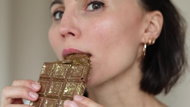 Close up of woman portrait eating handmade Dubai chocolate with green pistachio paste, cream and kataifi dough isolated on white background. Trend dessert. Banner