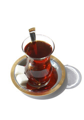 Glass of Turkish Black Tea with spoon and sugar cubes isolated on white