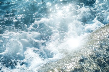 Ocean waves crashing on rocks, white foam, sunlight.