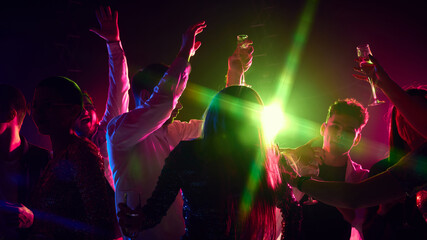 Group photo of friends toast and dance under radiant neon lights, laughter and music filling air in celebration of life and connection. Concept of party, youth, carefree, celebration. ad
