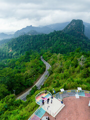 Aerial drone view of winding mountain road surrounded with greenery rainforest at Wang Kelian, Perlis, Malaysia.
