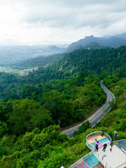 Aerial drone view of winding mountain road surrounded with greenery rainforest at Wang Kelian, Perlis, Malaysia.
