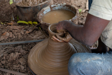 Hands of a potter at work. Potter making ceramic mug on the pottery wheel