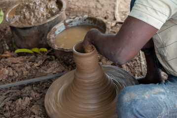 Hands of a potter at work. Potter making ceramic mug on the pottery wheel