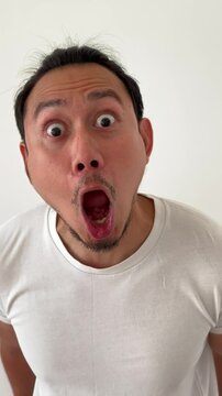 Vertical video of funny man do wow and shock face close to the camera.