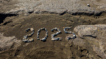 2025 Written with Stones on Sandy Beach by the Sea