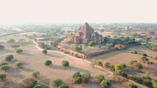Aerial view of the majestic Dhammayangyi temple amid the sun-kissed plains of Bagan, Myanmar, highlighting ancient burmese architecture and serene landscapes, drone establishing shot