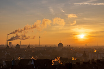 Sonnenuntergang über der Stadt Nürnberg an Silvester. Zu sehen sind rauchende Schornsteine und...