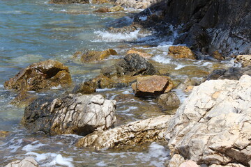 Tranquil nature scene with a sparkling river flowing through a lush forest, mountains in the background, and the sun casting golden light on the sandy beach, blending the beauty of earth, water, sun