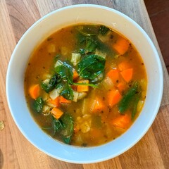 Carrot and spinach soup in white bowl or dish