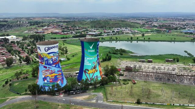 SOWETO, SOUTH AFRICA, aerial video footage flying right around painted Orlando Towers, chimneys at Soweto, a famous landmark of the township of Johannesburg, located next to Orlando Dam. 