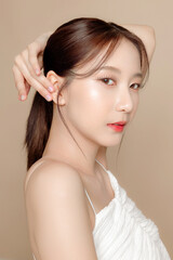 Fototapeta premium Young Asian beauty woman pulled back hair with korean makeup style on face and perfect skin on isolated beige background. Facial treatment, Cosmetology, plastic surgery.