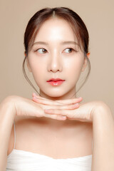 Obraz premium Young Asian beauty woman pulled back hair with korean makeup style on face and perfect skin on isolated beige background. Facial treatment, Cosmetology, plastic surgery.