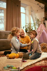 Children enthusiastically perform pretend health check-up with toy medical tools, guided by...