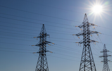 support for a high-voltage power line against the blue sky and sunlight. for design and background