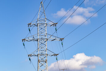 support for a high-voltage power line against the blue sky and sunlight. close up