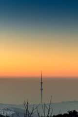 Colorful sunset in a clear sky above cities smog with  the TV tower