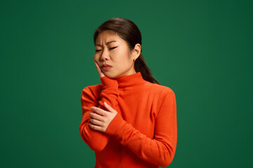 Woman holding jaw with visible discomfort, possibly due to dental infection or viral swelling....