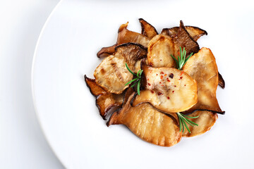 Fried Pleurotus eryngii mushrooms on a white plate.