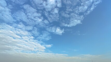 Bright blue sky with fluffy white clouds on a sunny day