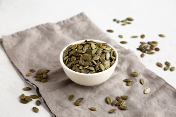Healthy Raw Organic Pumpkin Pepita Seeds in a Bowl, side view.
