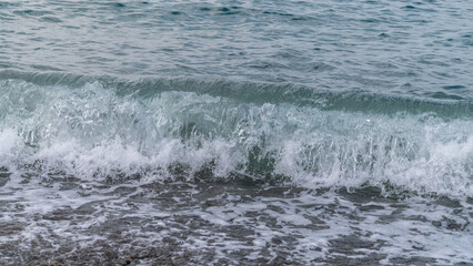 Water sea beach. Wave ocean blue. Stone texture reflection sun. Surface coast pebbles. 