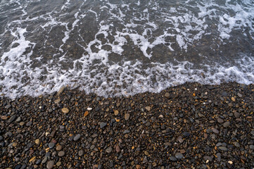 Water sea beach. Wave ocean blue. Stone texture reflection sun. Surface coast pebbles. 