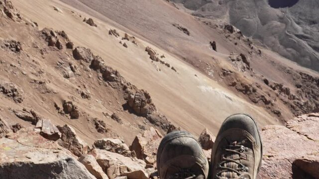 Hiking boots rest high atop Cerro Keops, Argentina, peaceful mountain summit view