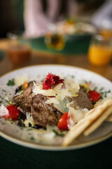 Closeup of delicious steak salad with bread and vegetables.