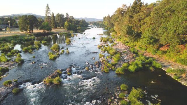 Fly Pasy White Water Rapids on Lush Oregon River at Sunset. North Umpqua River, Roseburg. Summer Low Water Line Showing Green Islands and Vibrant Forests. Slow Calm Reflective Water