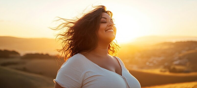 Carefree plus size woman enjoying golden sunset in scenic landscape