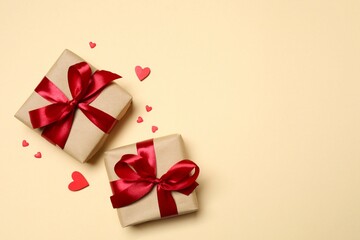 Beautiful gift boxes with red hearts on color background