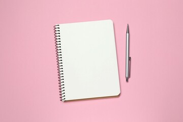 Top view photo of notebook with a pen on color background with blank space. Business concept